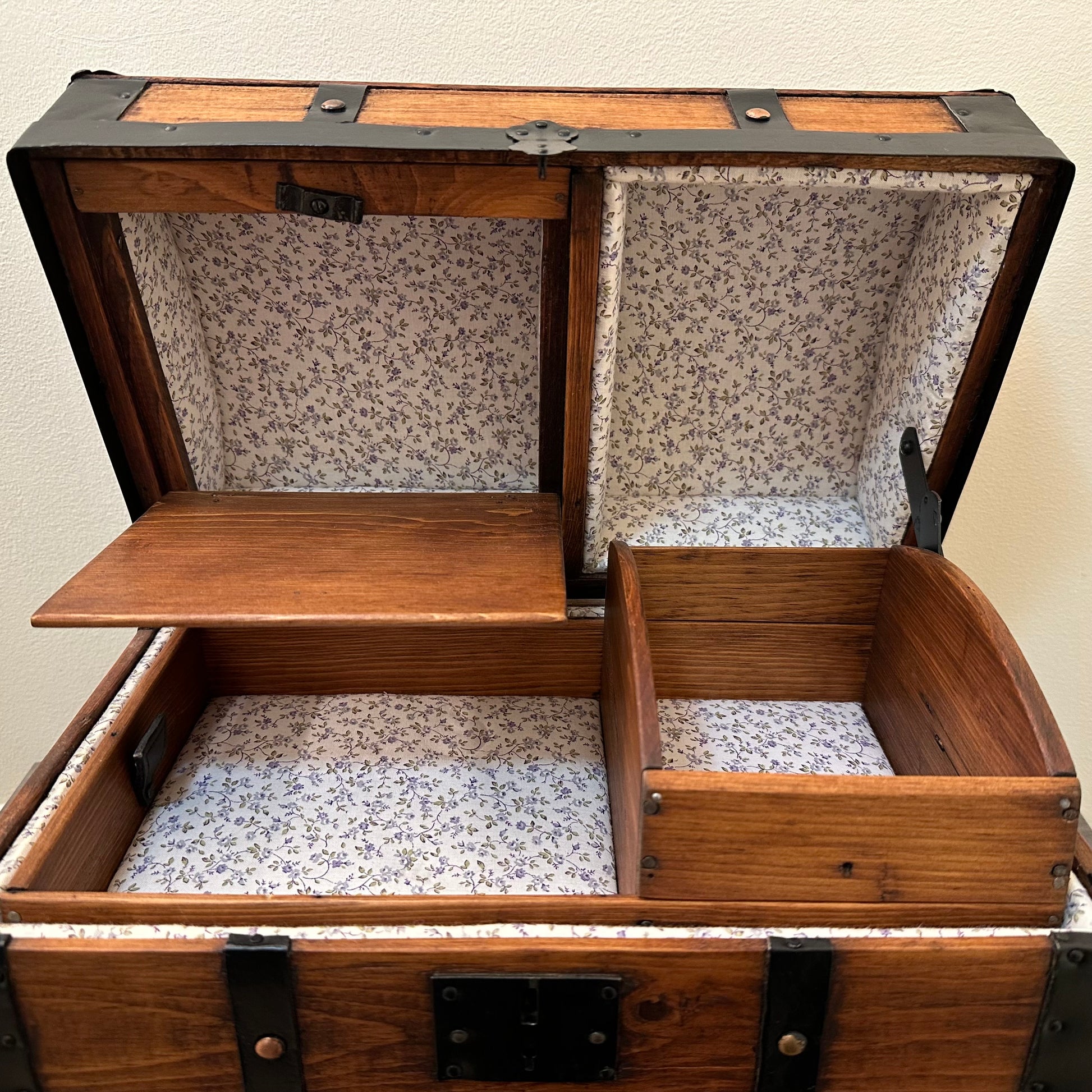 Wooden trunk with floral interior lining on a plain background