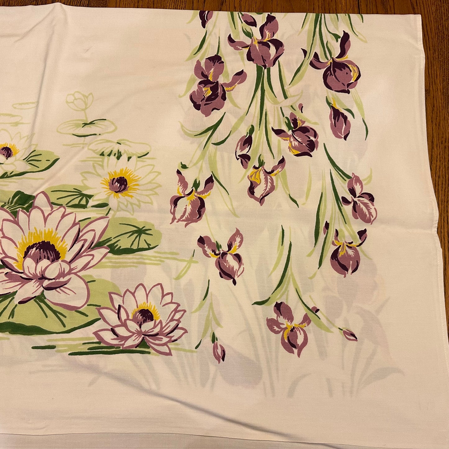 Floral patterned fabric with purple flowers and green leaves on a beige background