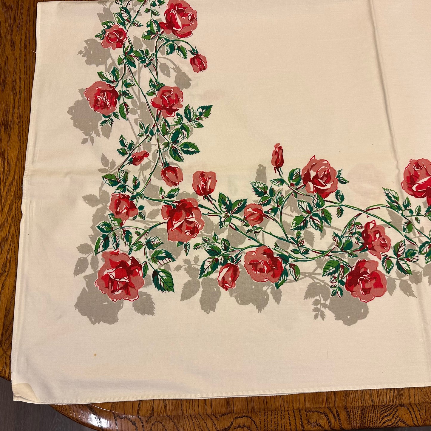 Embroidered red roses on a beige fabric background