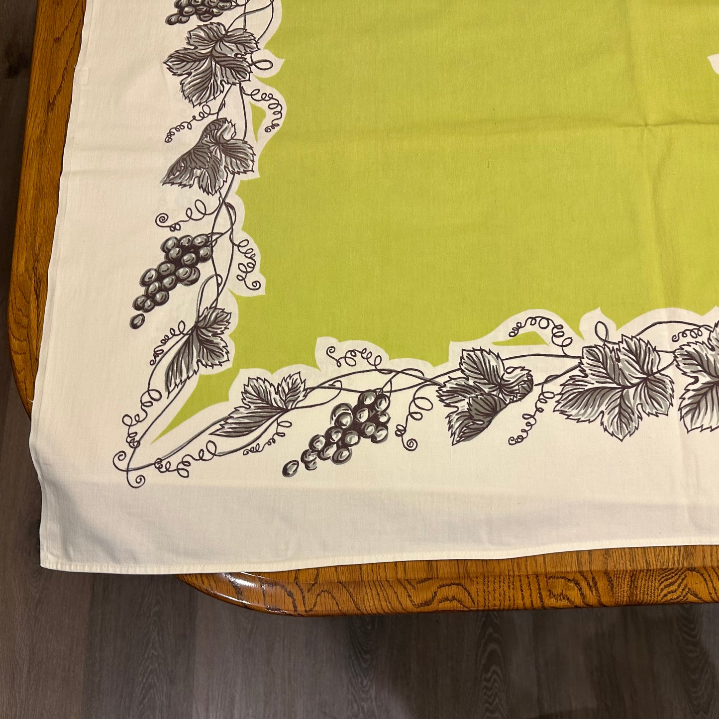 Tablecloth with grapevine design on a wooden table